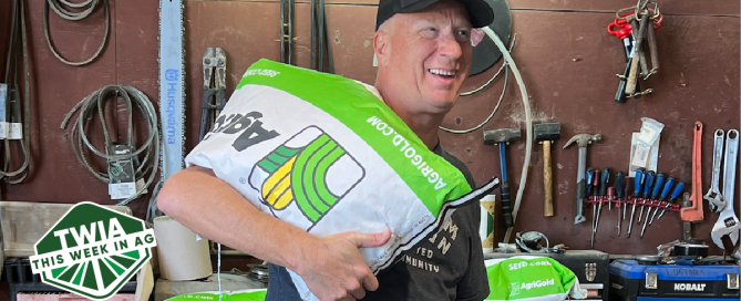 A mid shot of author, Fred Nichols, laughing and holding a seed bag in one hand.