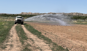 A water truck spraying nutrients across the field.