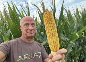 Author Fred Nichols looking impressed with a corn he's holding in his hand.